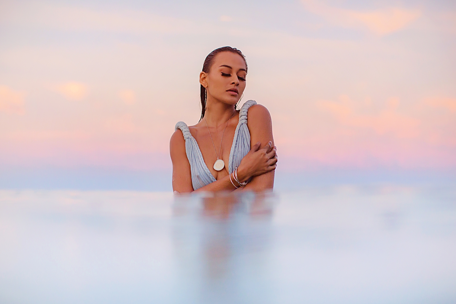 Model posing in the water wearing a seashell necklace on Maui