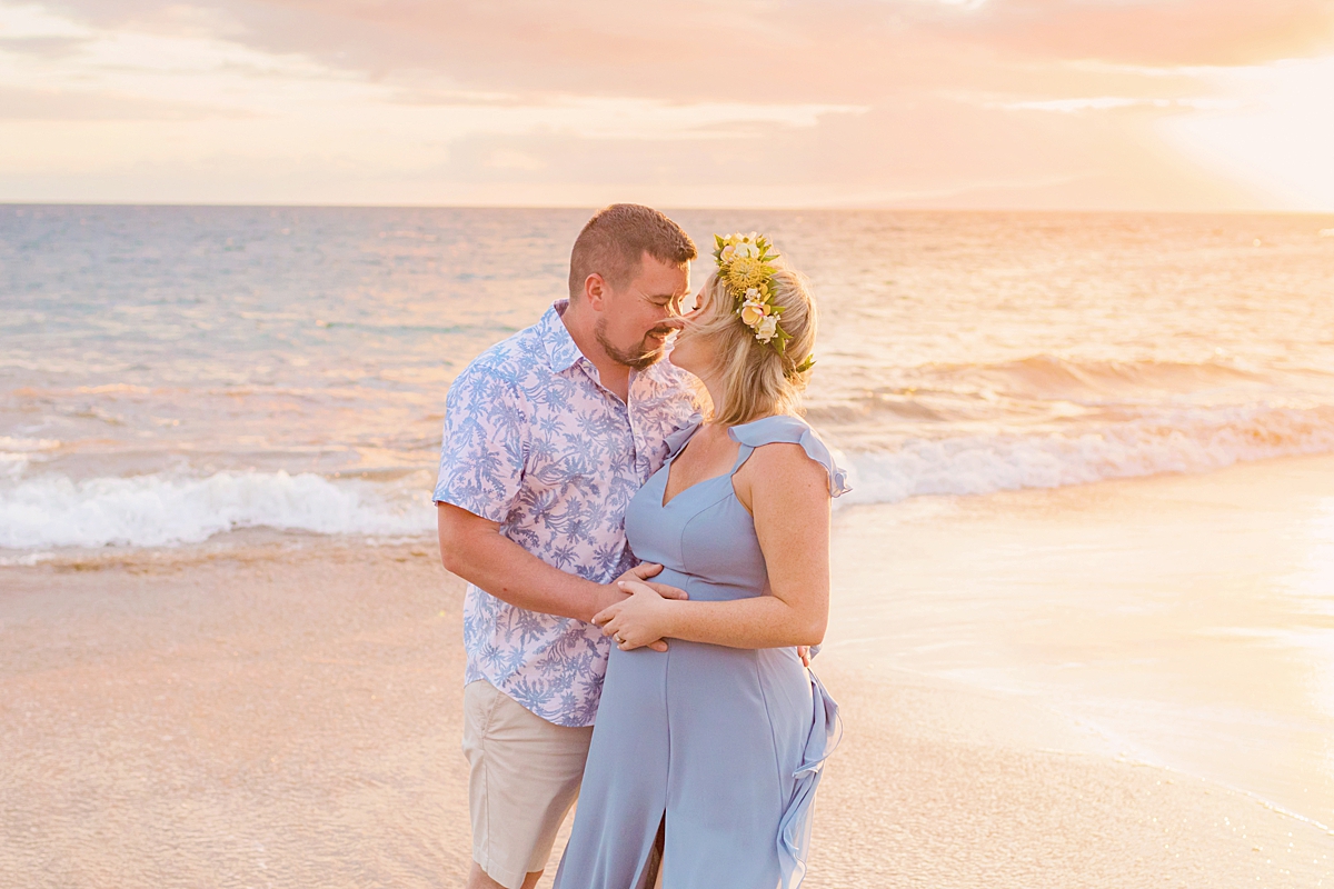 young couple smiling and touching noses at the beach during their sunset maternity portraits on Maui with Love + Water