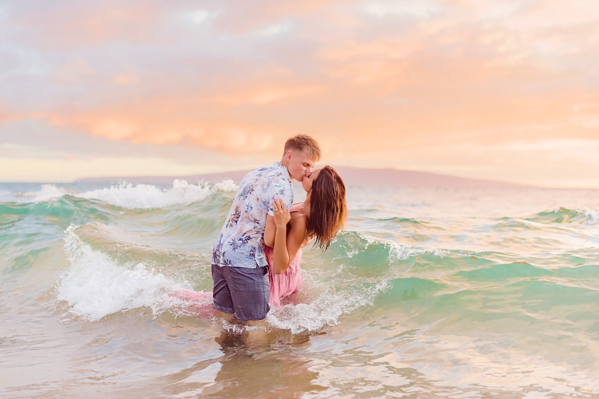 couple doing a dip and kissing in the ocean