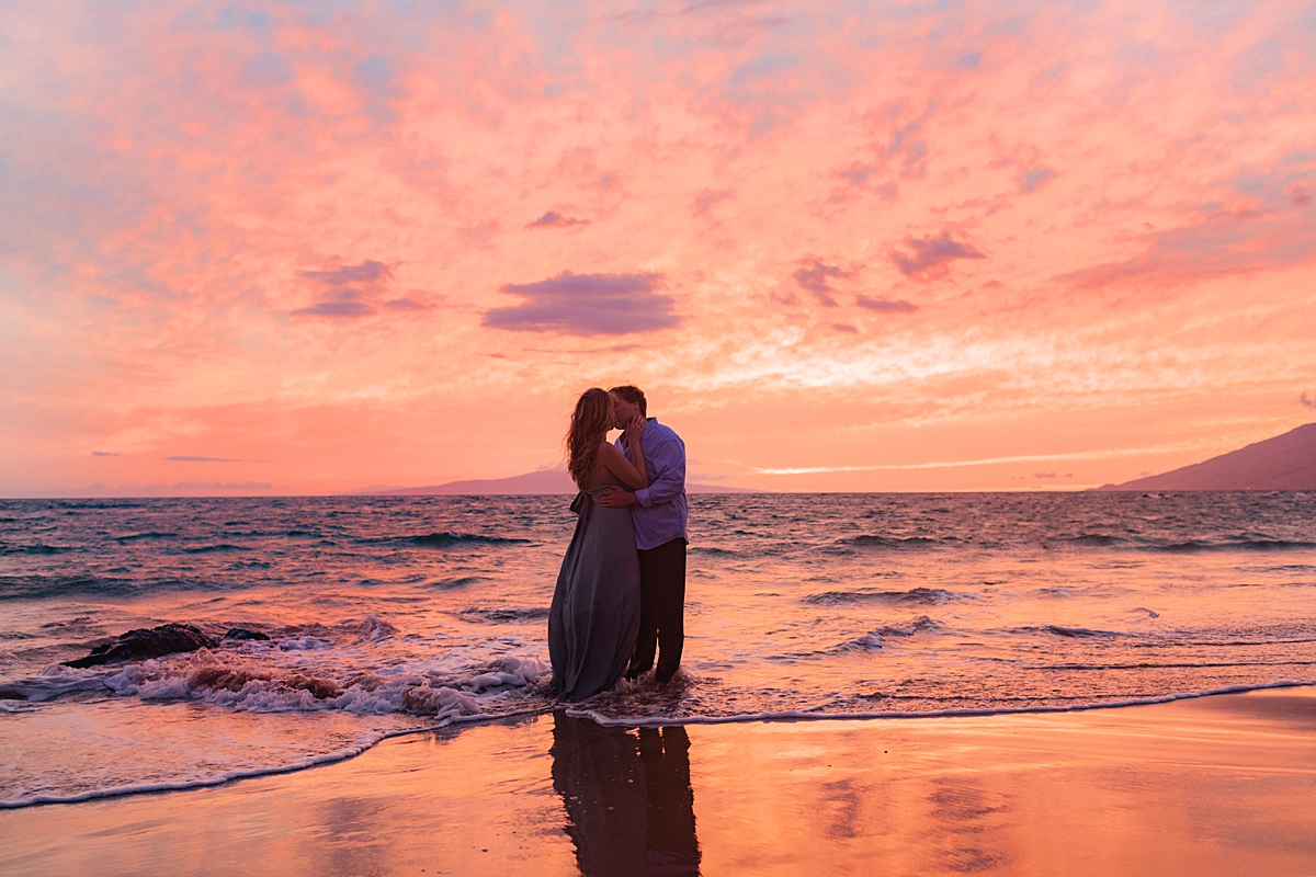 Beach sunset photoshoot with couple silhouetted by the setting sun