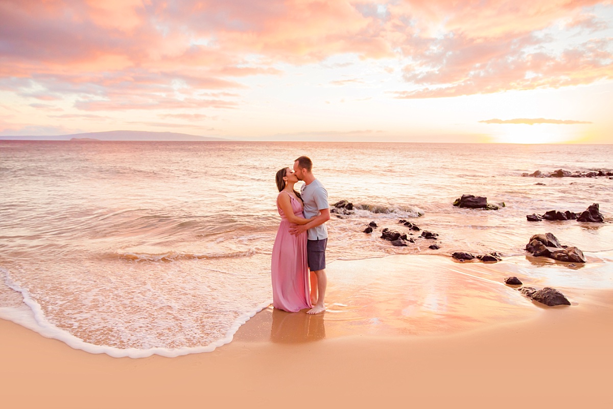 A newly engaged couple kisses on the beach during a surprise proposal photos session with Love + Water in Wailea, Maui, Hawaii. 