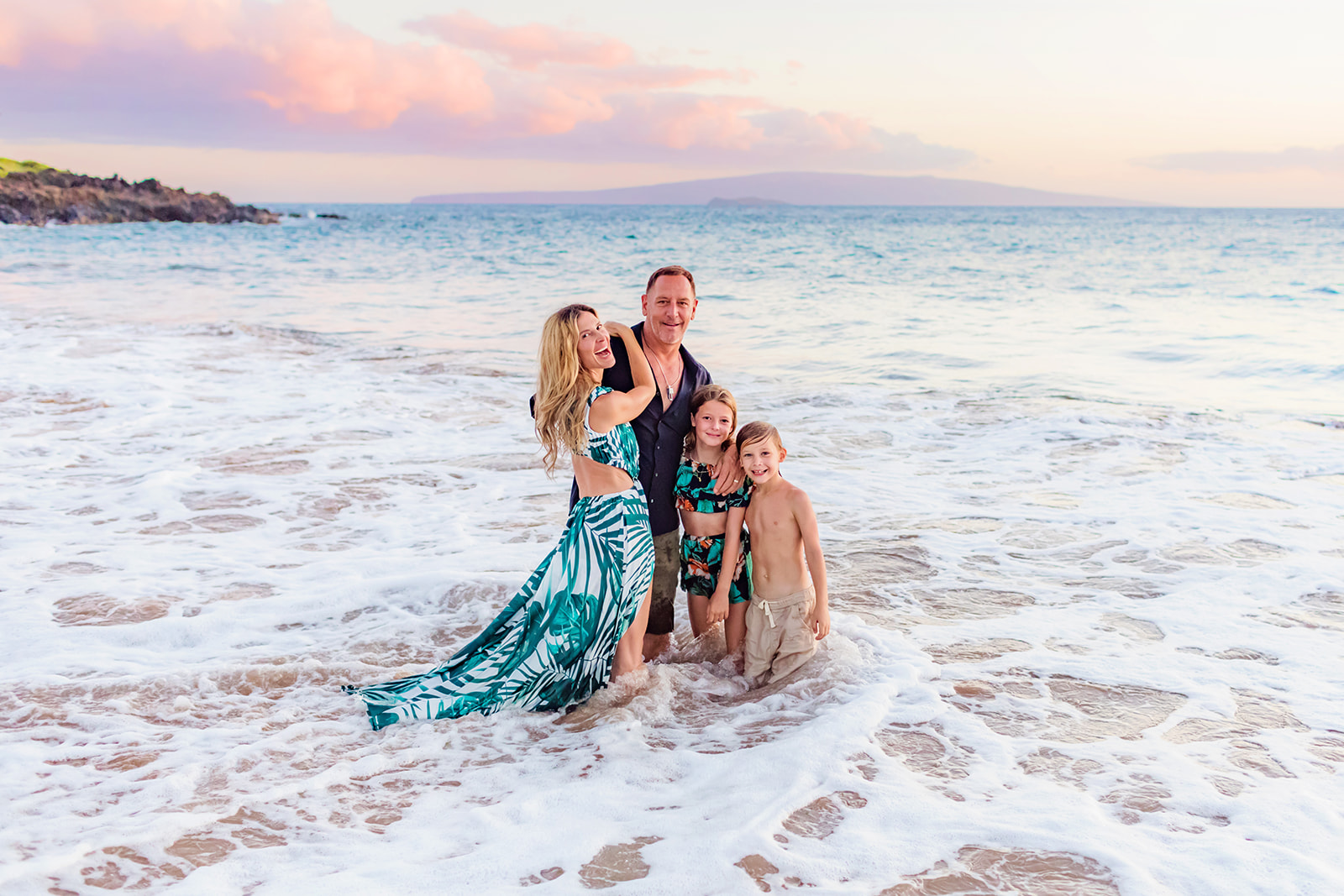 Fun family laughs in the shoreline on Maui with love and water portraits in Wailea