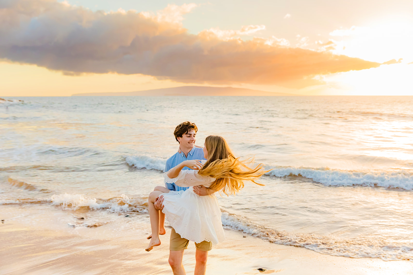 A man swings around his beautiful fiance during Mia Maples' engagement photo session on the beach in Maui. 