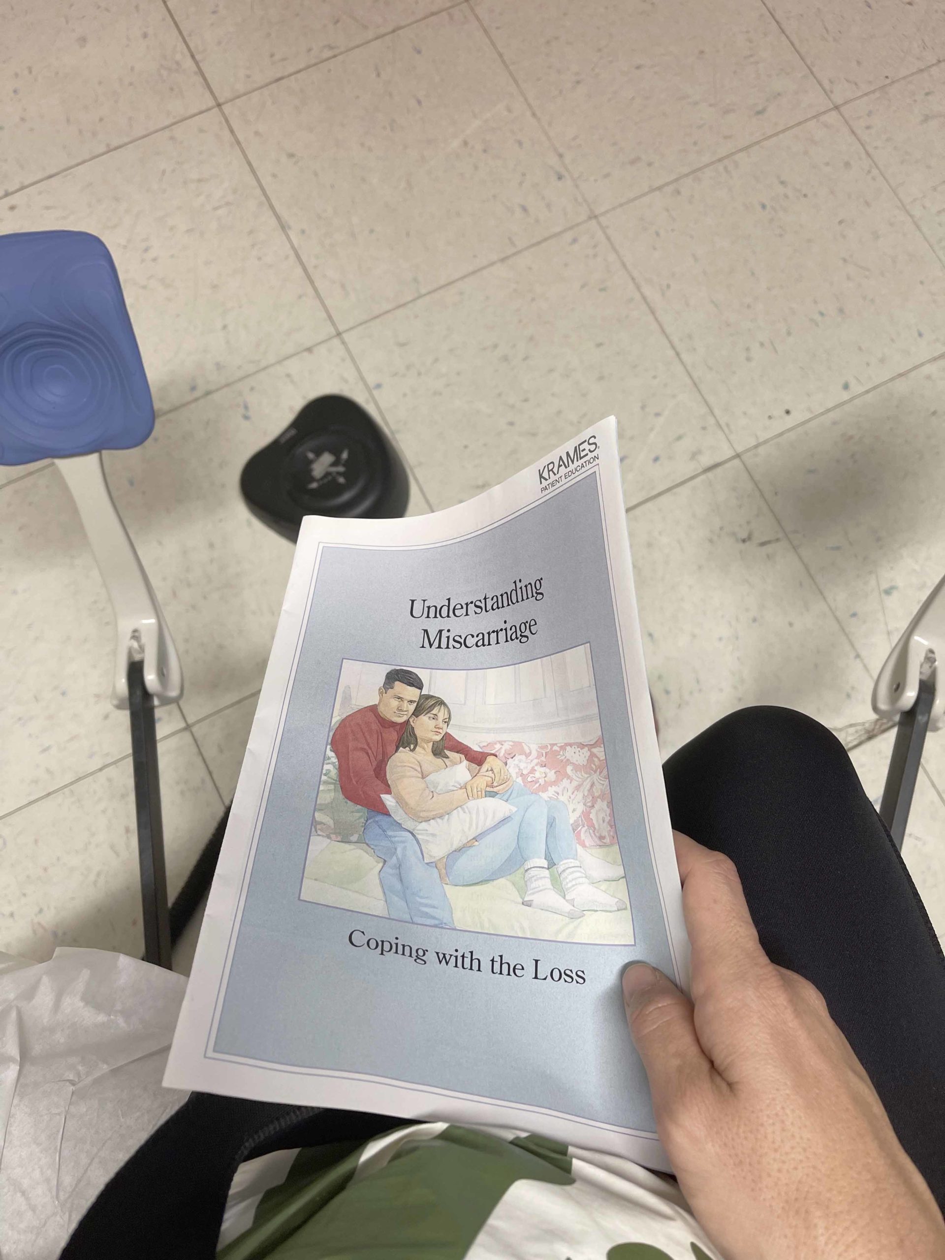 woman sits on bed at kaiser with miscarriage brochure