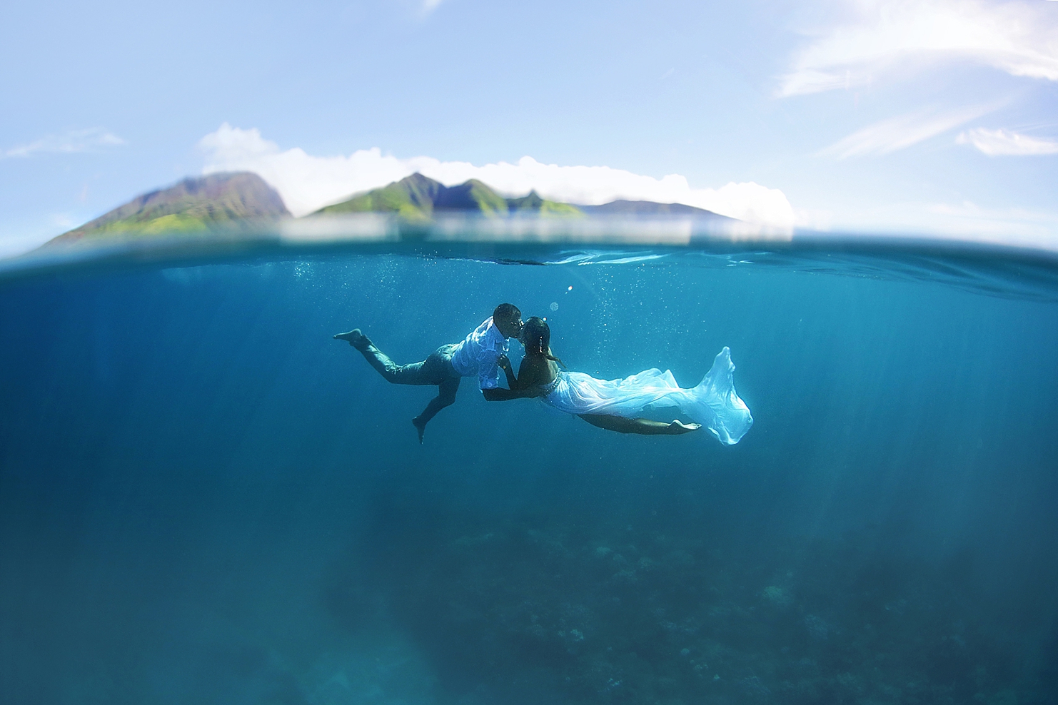 beach photoshoot ideas hawaii trash the dress portrait featuring couple in wedding attire kissing underwater in maui by love and water photography
