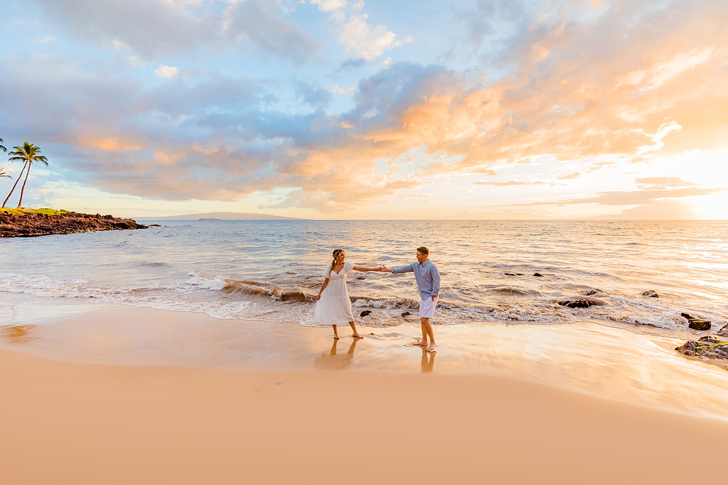 couple dances at sunset on the beach in wailea during their couples photoshoot with love and water