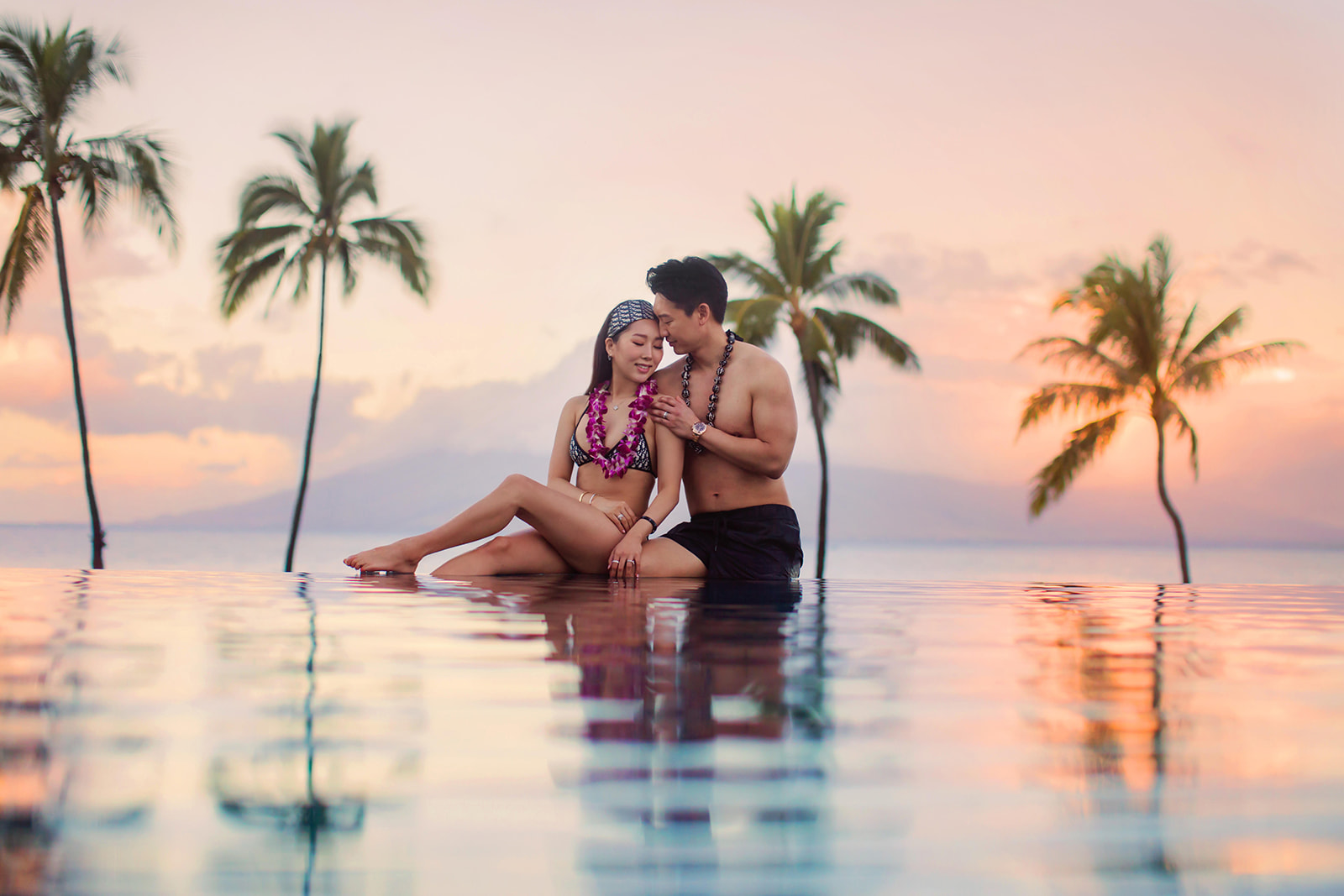 hawaii beach photoshoot idea four seasons resort maui hawaii infinity pool photoshoot with couple wearing lei at sunset