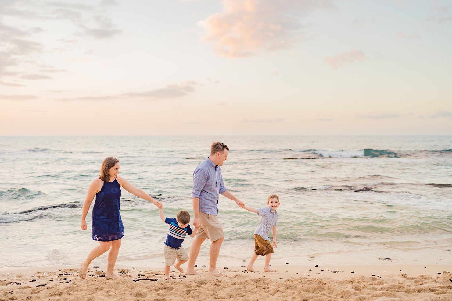 family holds hands and walks off camera for their family photography big island portrait session