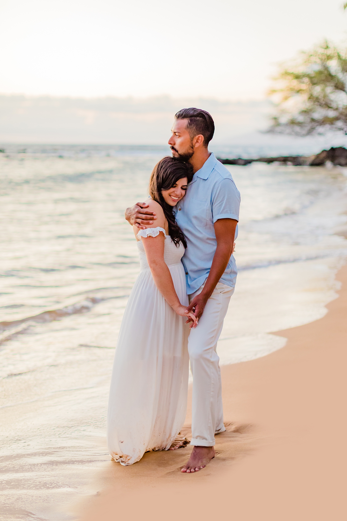 couple cuddles on the beach during their maui honeymoon photoshoot in wailea with love and water