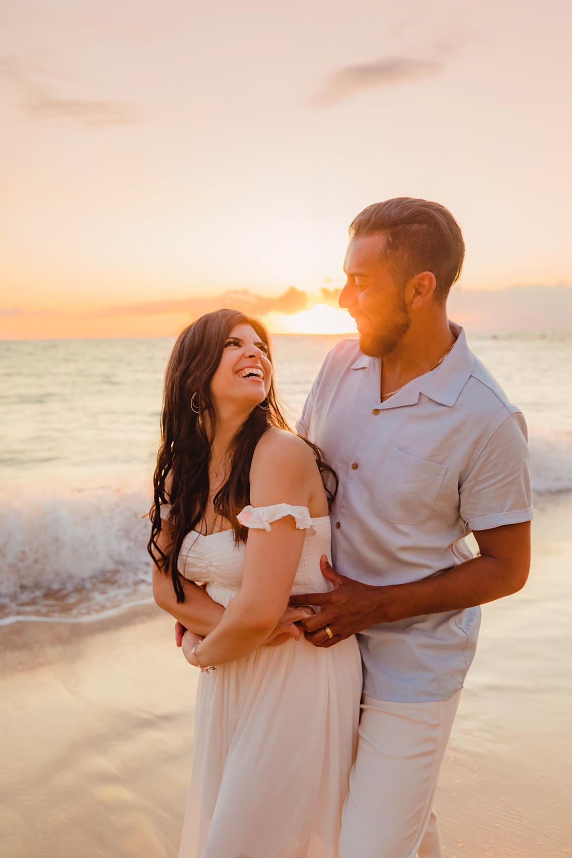 sunset couples photo of two young honeymooners laughing and smiling on the beach in hawaii