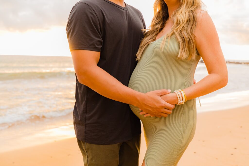 closeup of couple snuggling pregnant belly on the beach in wailea