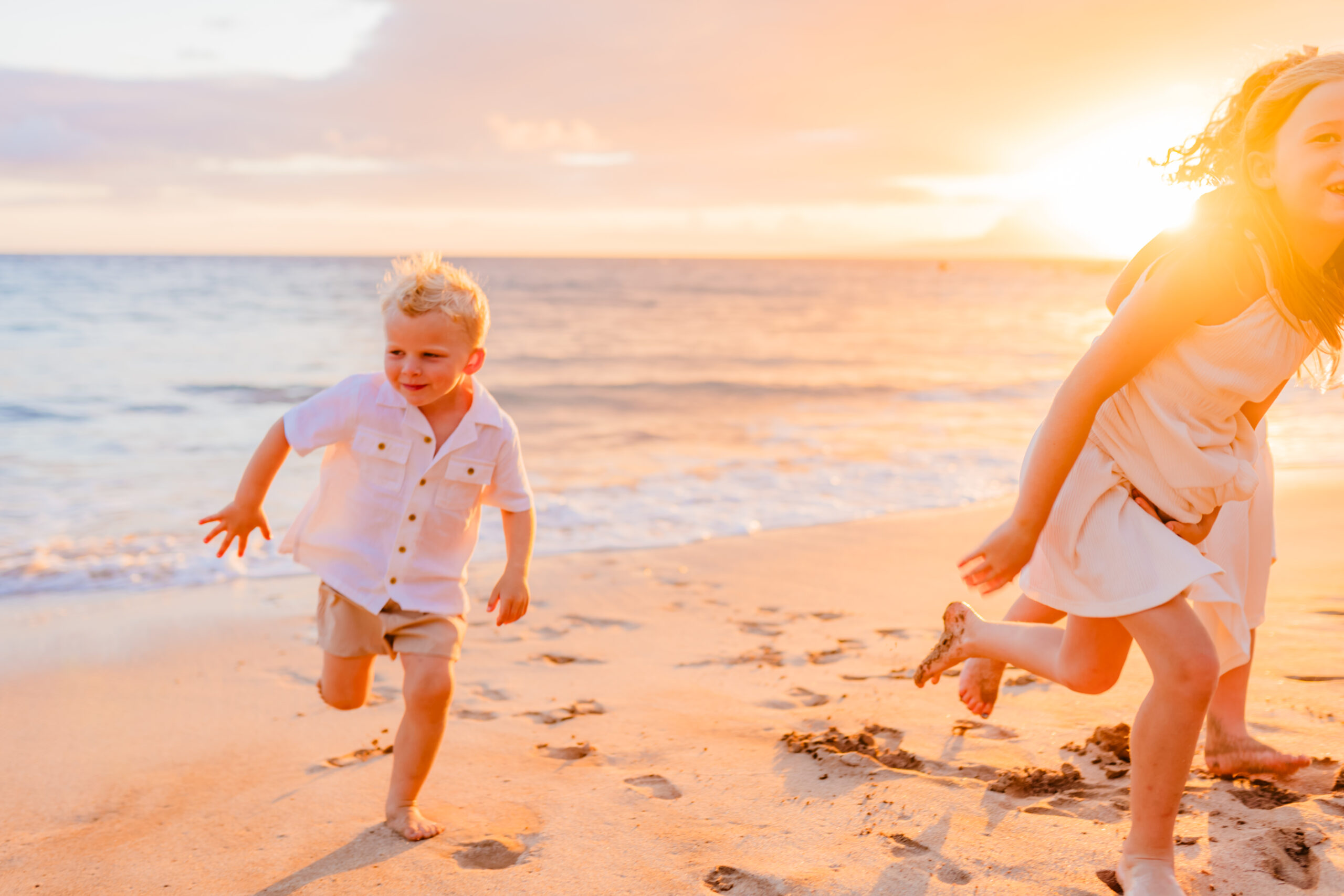 Little boy and his two sisters caught in action running up the beach on Maui