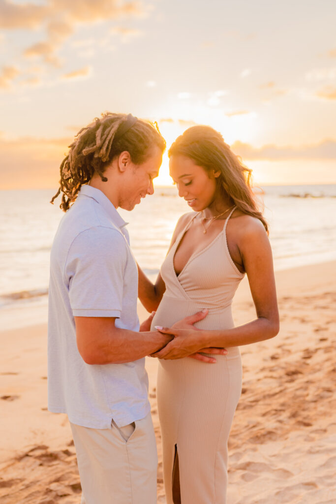 Pregnant woman's partner places his hand on her bump during their maternity photoshoot