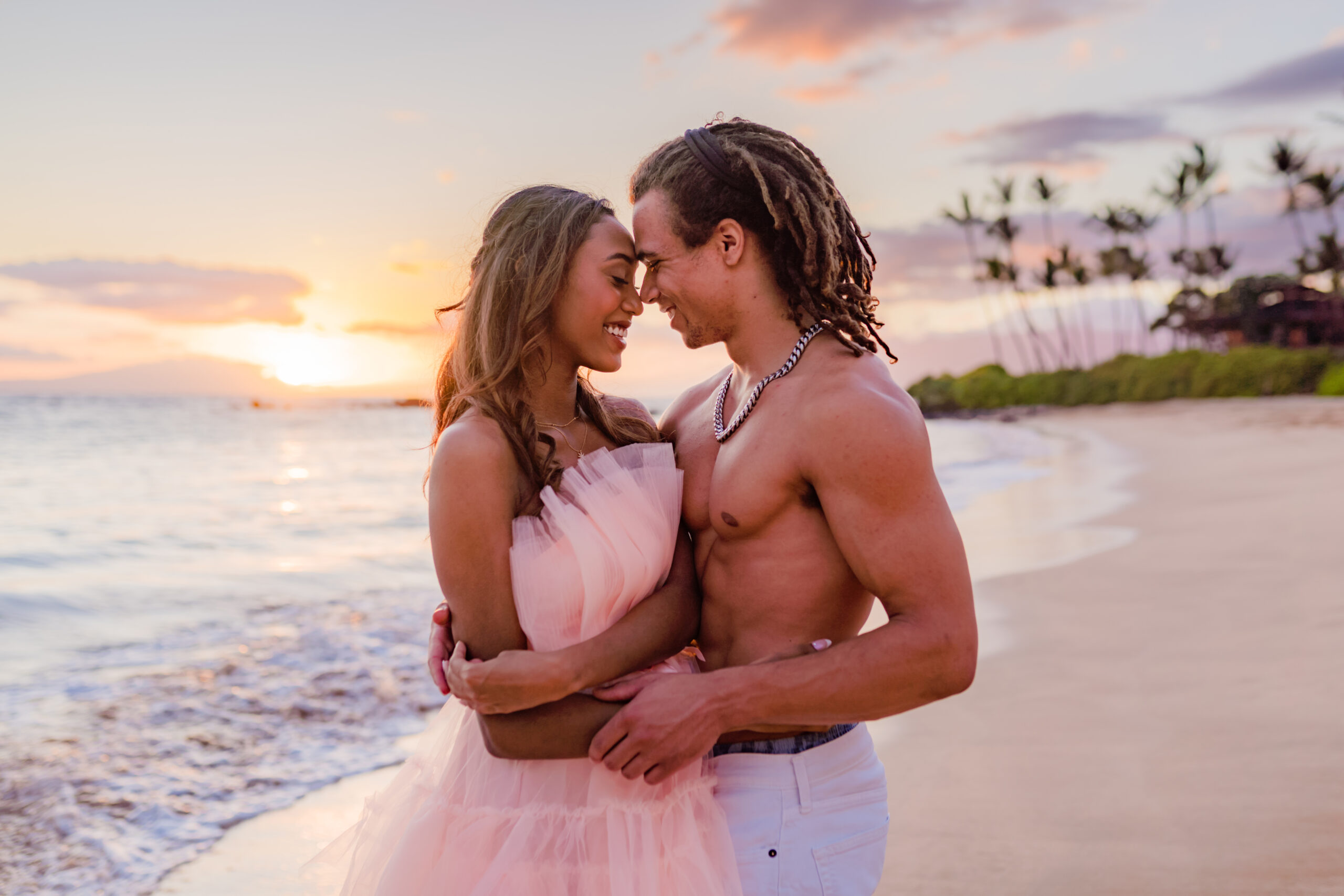 Woman in gorgeous tulle dress poses for photos with her partner to celebrate their babymoon