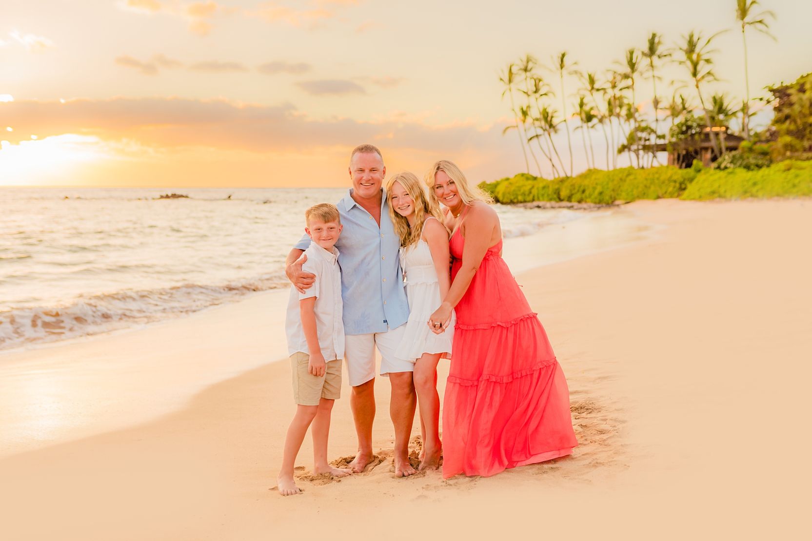 Family wears coordinating coral and blue outfits for beach Maui family pictures by Love and Water Photography in Wailea.