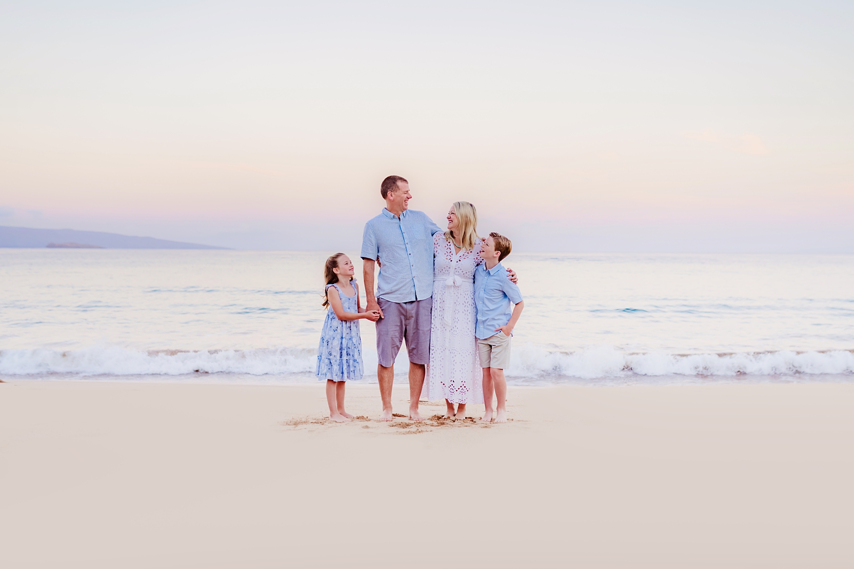 cute family at sunrise wearing coordinated blue and white outfits