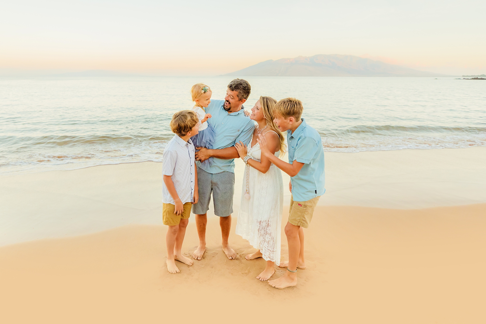 beautiful maui family sunrise portrait session with family of five holding young daughter and smiling