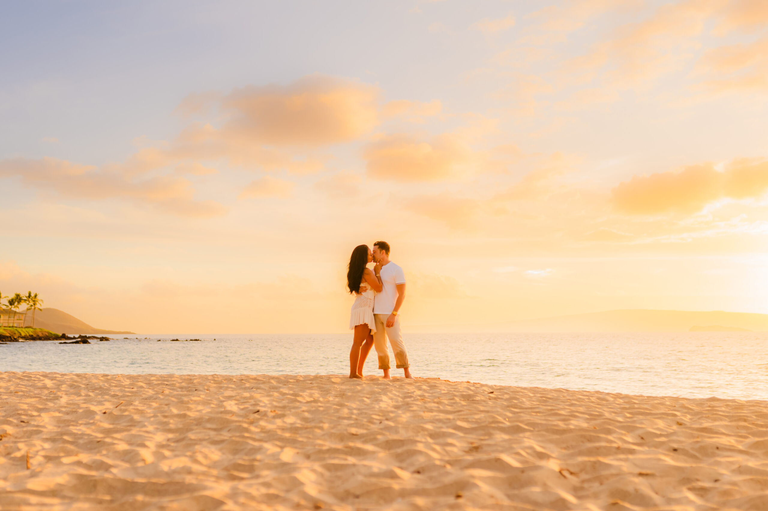 couple kisses on beach in hawaii during photoshoot