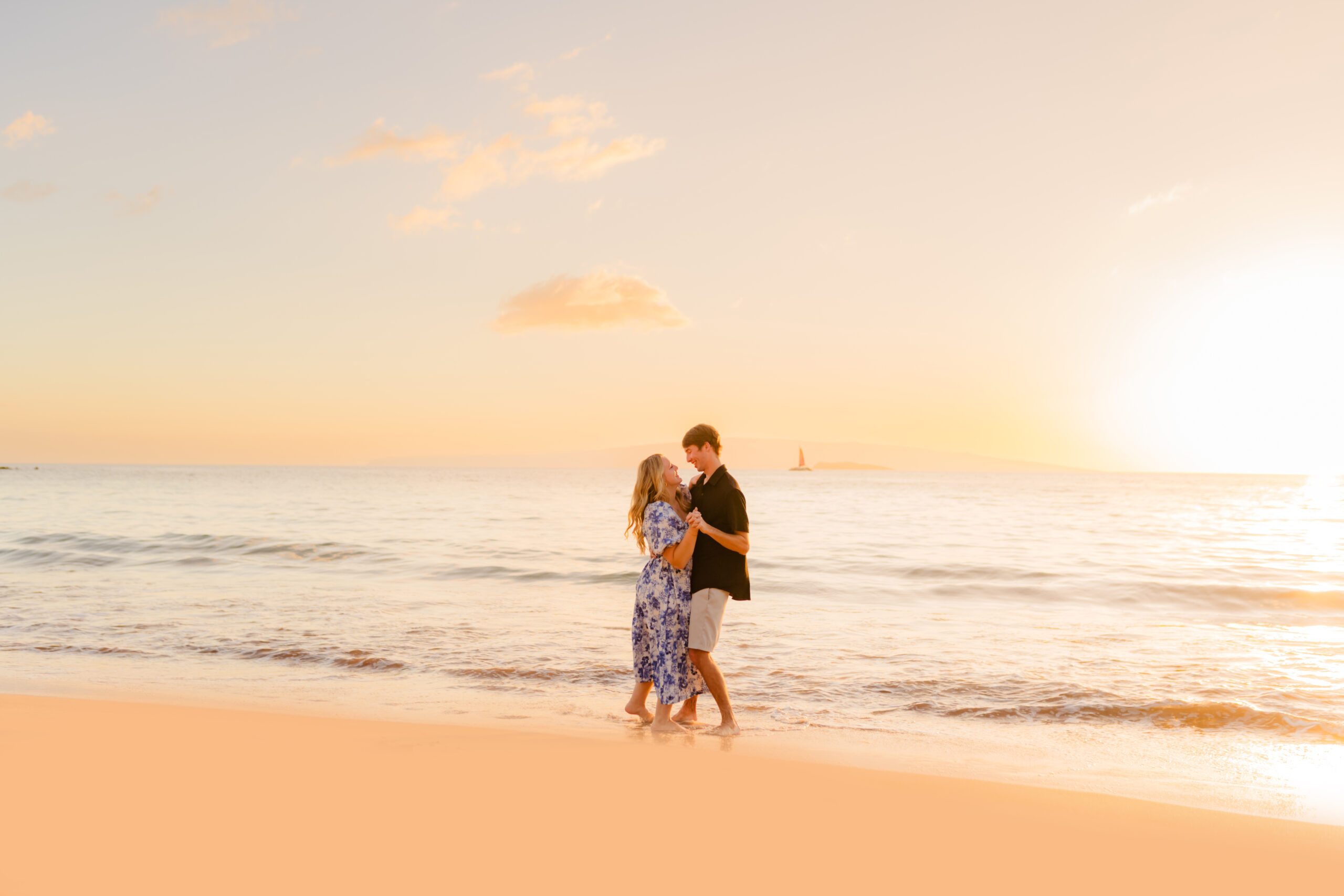 couple in hawaii pose on the beach during a sunset photoshoot