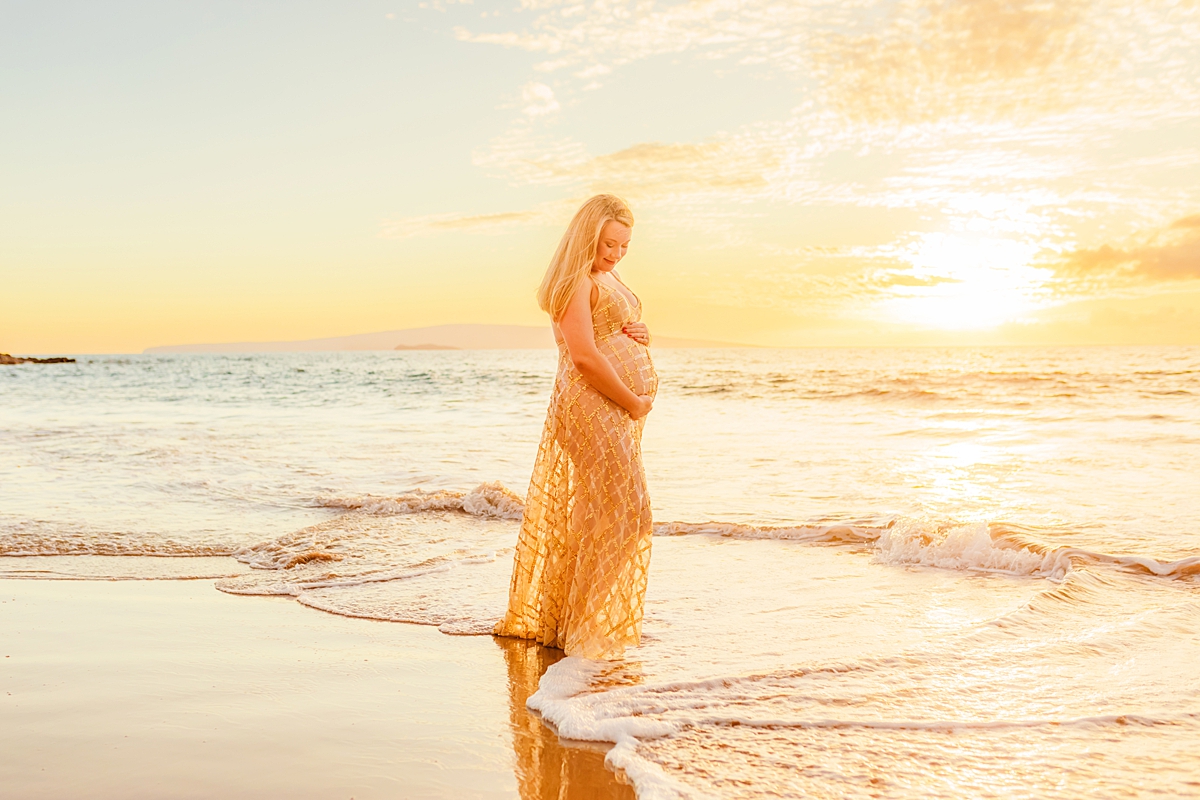 Pregnant woman wearing a beautiful maternity photoshoot dress with gold detailing for a maternity photoshoot on Maui, Hawaii with love + water photography.