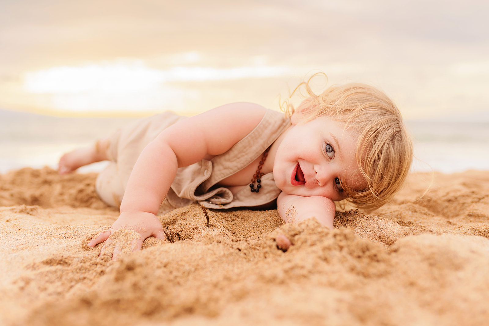 young toddler boy posing on the sand in wailea during their maui photoshoot with love and water