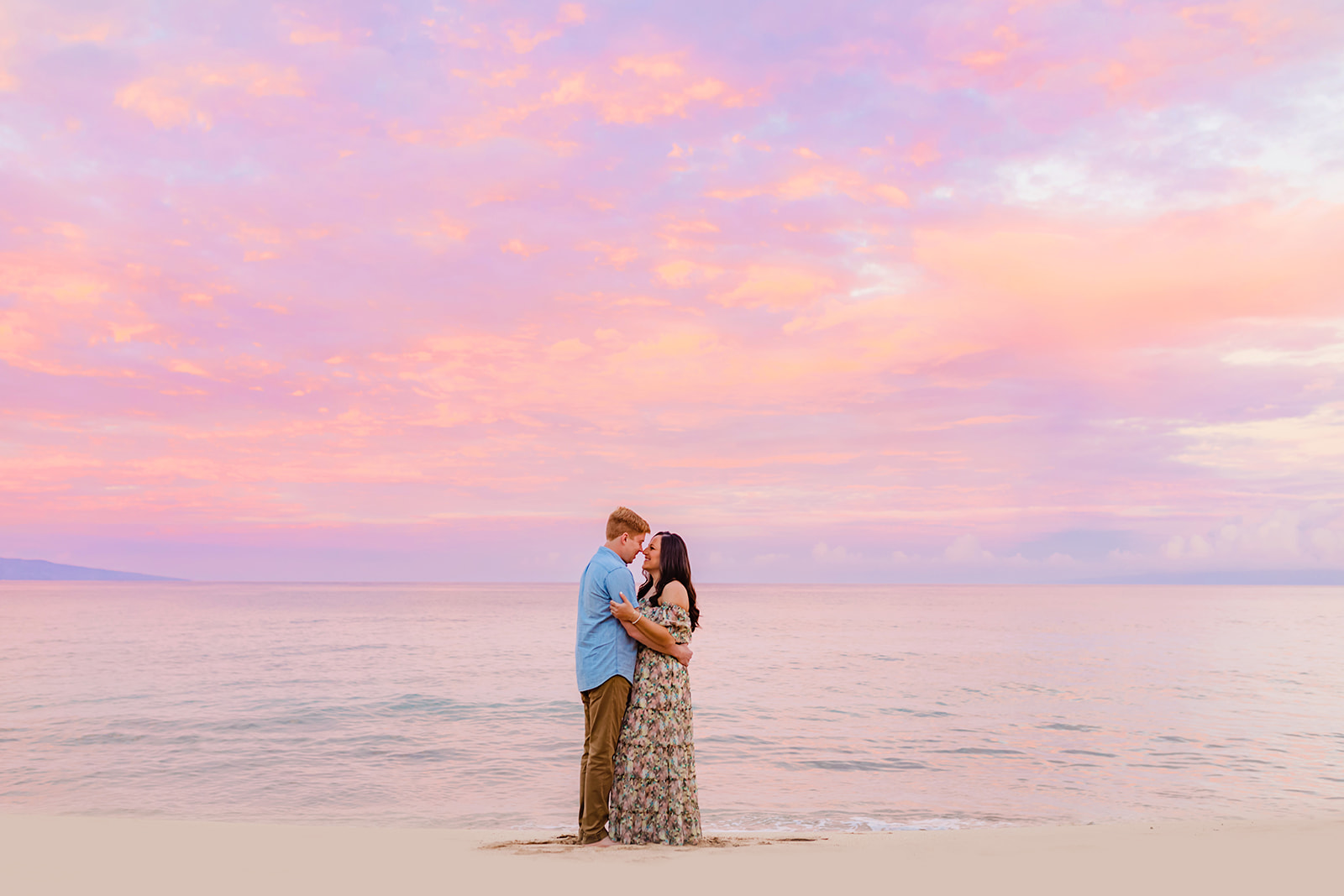 An engaged couple standing together in the water for sunset engagement photos on Maui with Love + Water Photography.