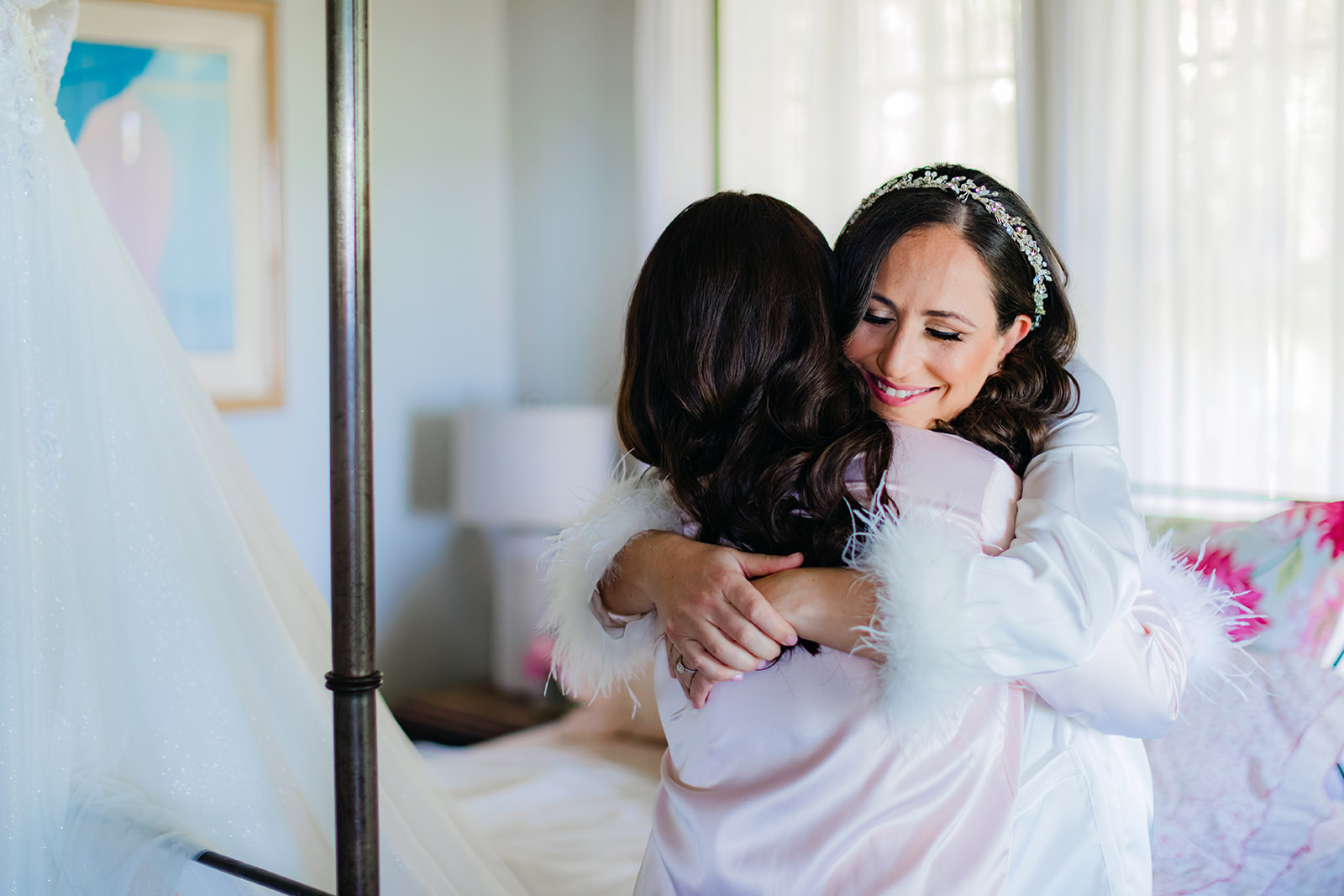 A beautiful bride hugs her friend while getting ready for her Maui wedding at Olowalu Plantation House.