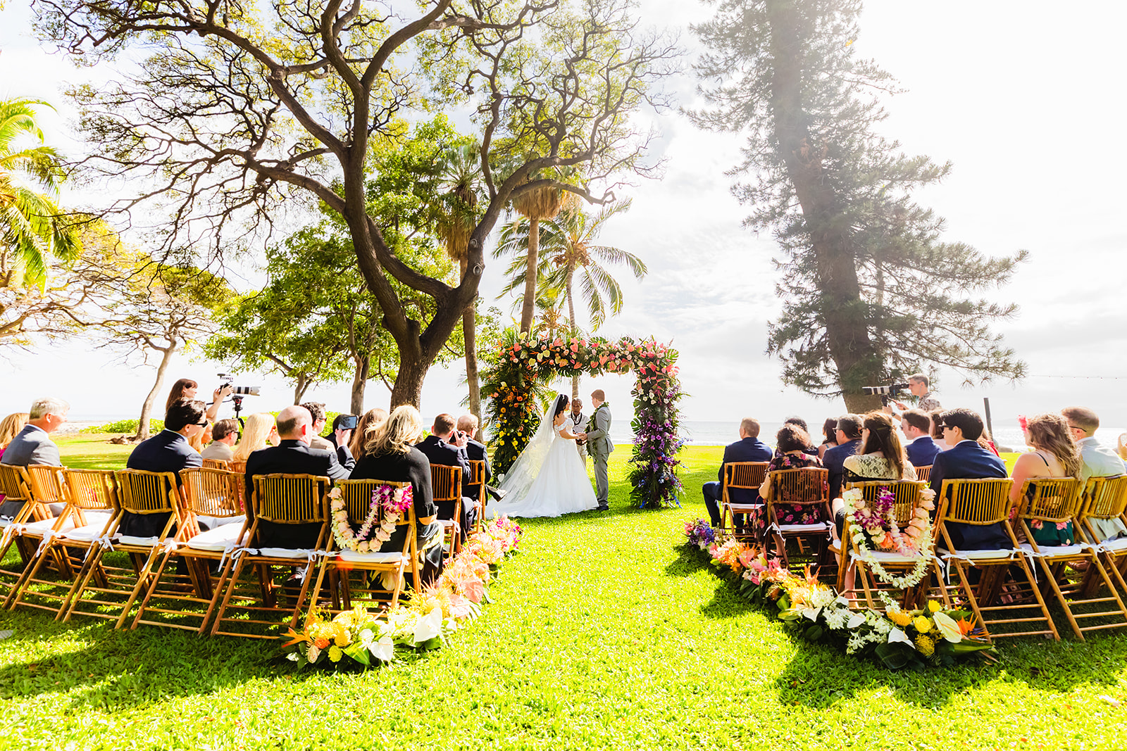 Guests sit at a beautiful ceremony setup by the ocean for a wedding at Olowalu Plantation House on Maui.