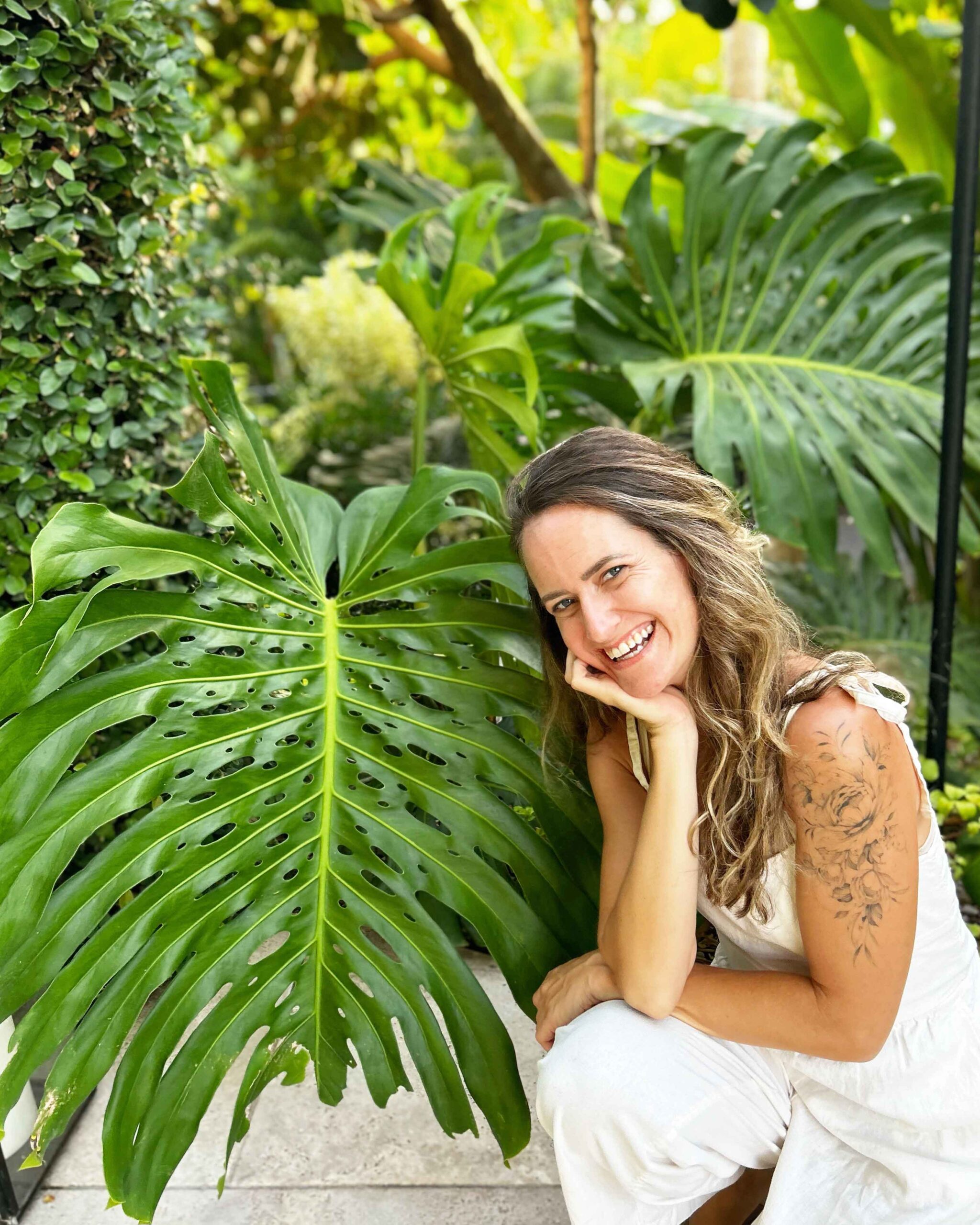 Woman poses next to huge monstera leaf at Hotel Wailea on Maui