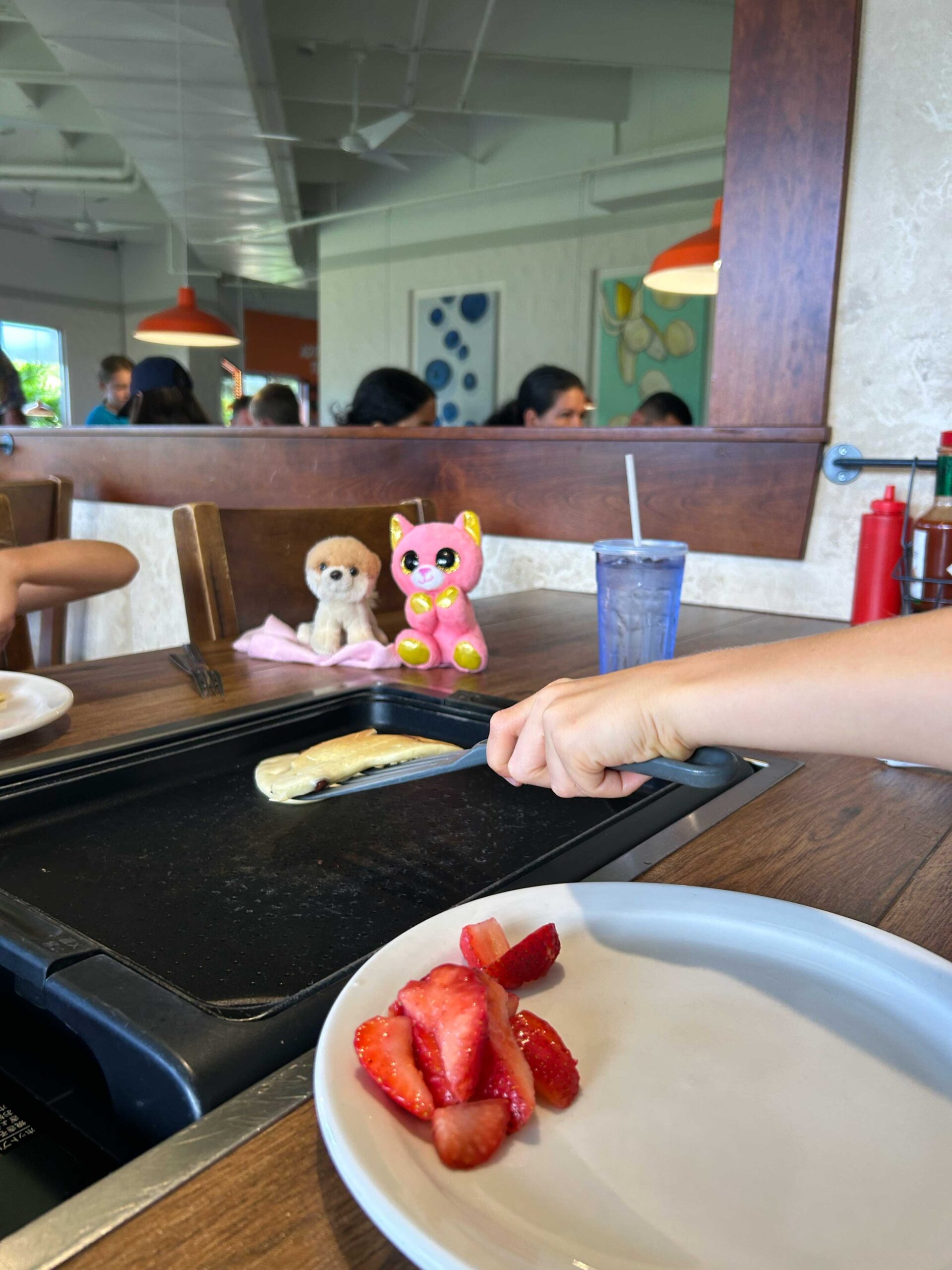 Maui travel with toddlers! Man flips pancakes for his kids at slappy cakes on Maui