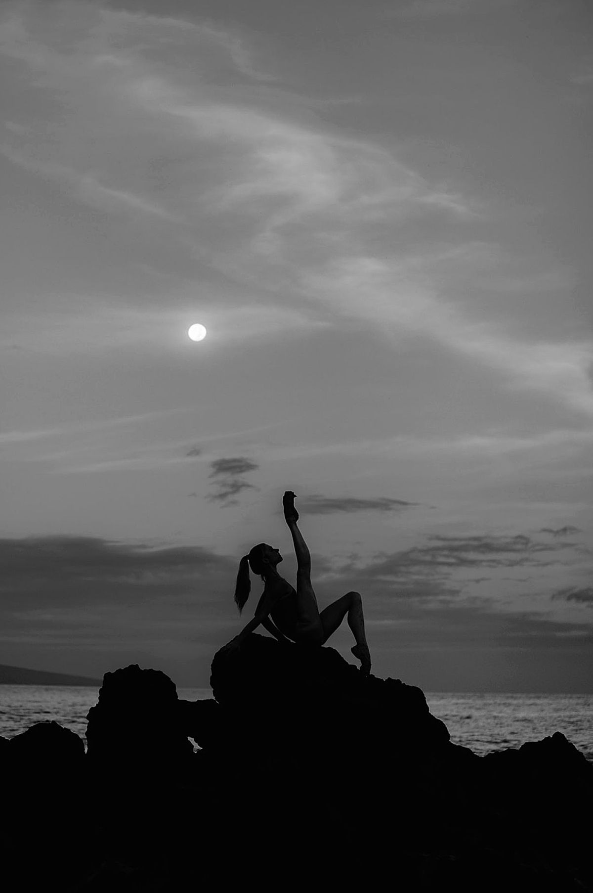 ballerina poses under full moon laying on lava rock in maui photographed by love and water