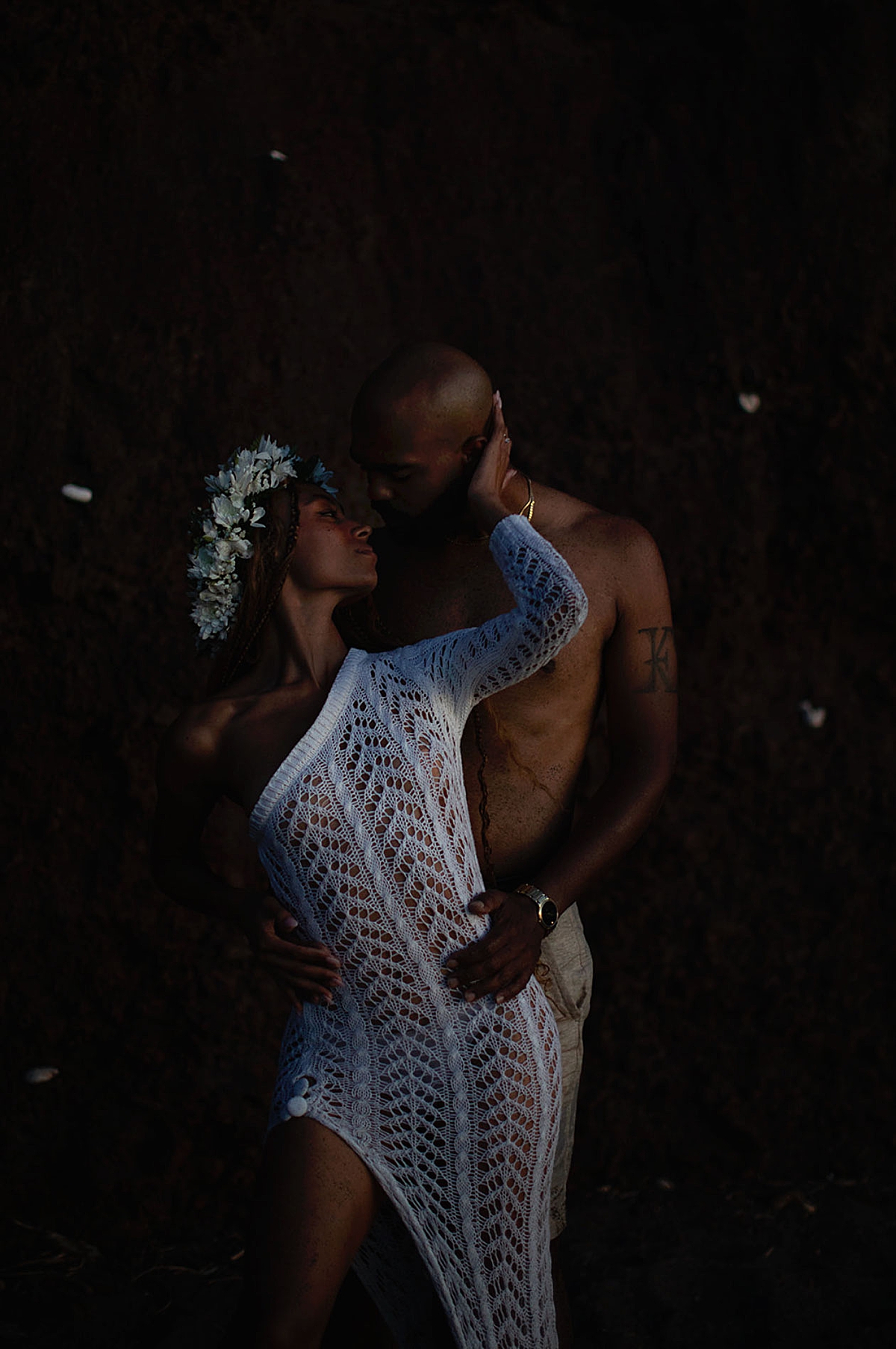 A romantic portrait of a couple standing on a rock formation, the cool blue tones of the hour wrapping around them.