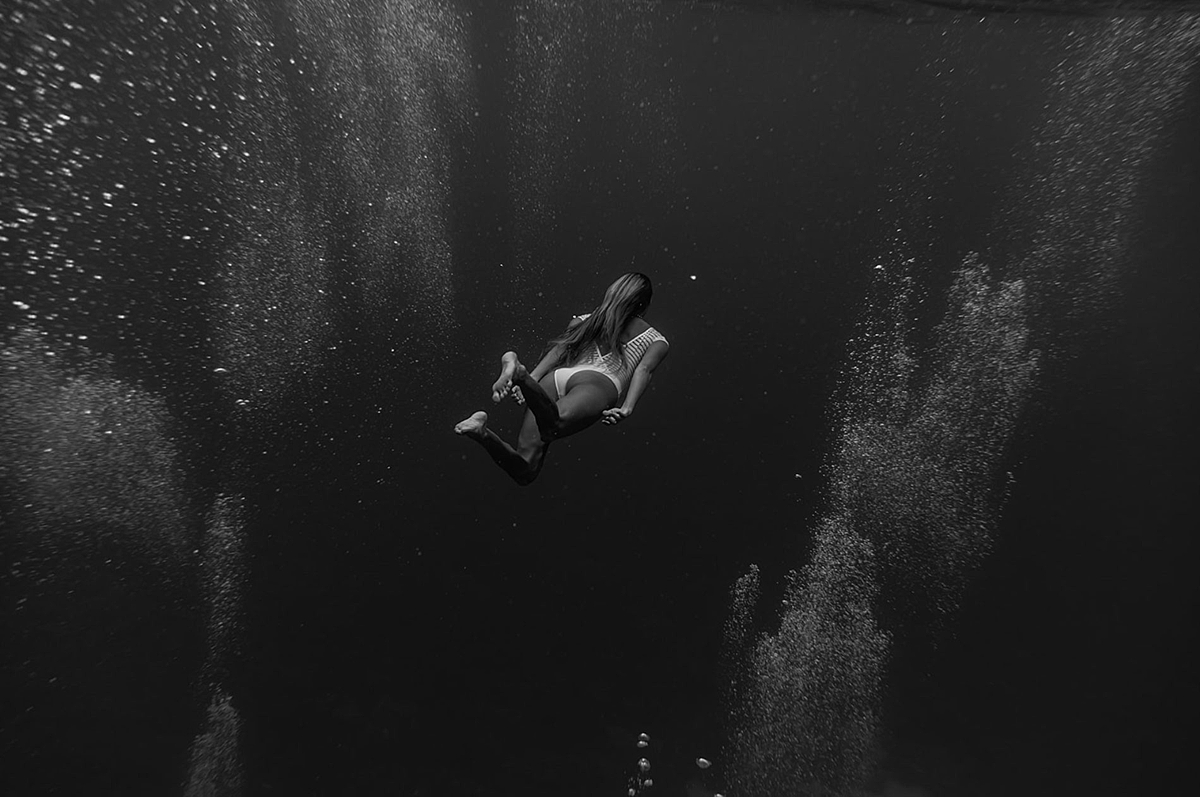 underwater portrait of woman swimming in the ocean and bubbles rising to the surface