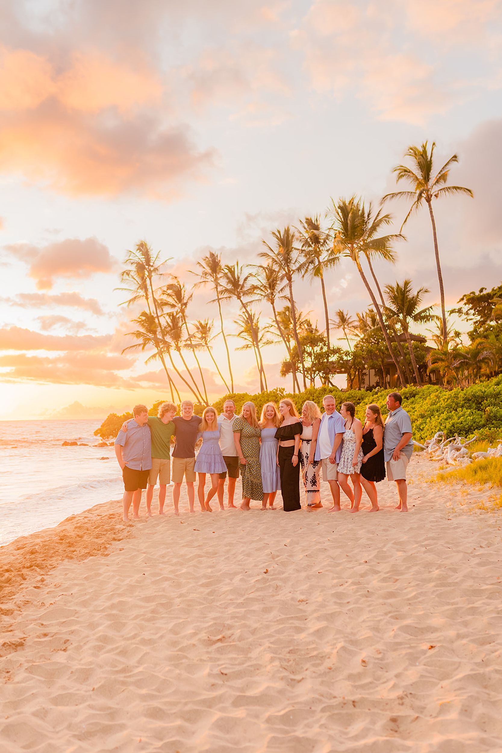 Large group of extended family laughing on a family-friendly beach in Wailea as their photos are captured by Love and Water Photography