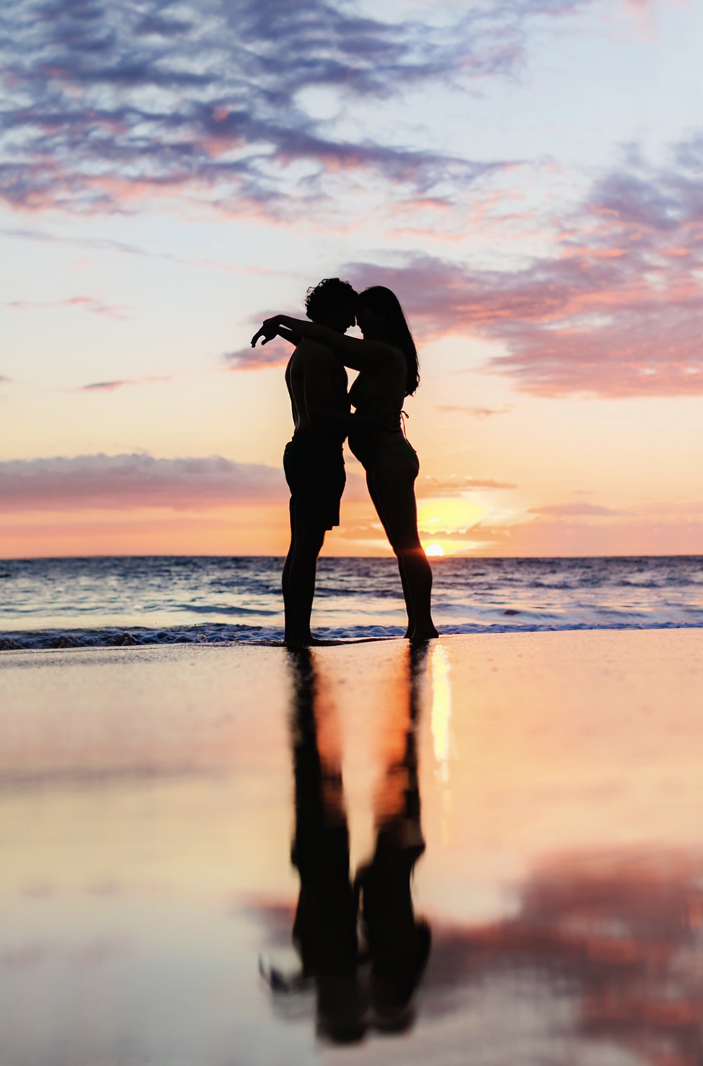 Pregnant couple silhouetted by the sunset in Wailea during their Maui photoshoot with Love and Water