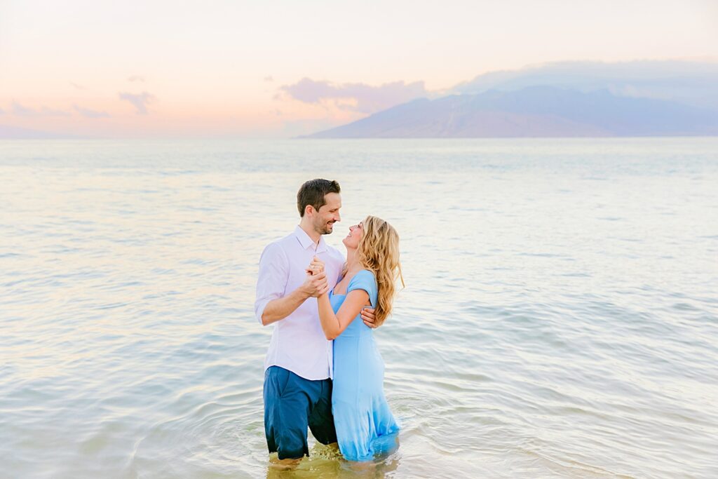 couple dances in the ocean in wailea, maui during the love and water photography shoot at the beach