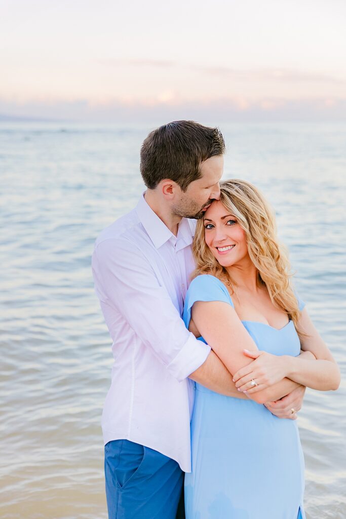 man kisses his wife's head during their sunrise Maui honeymoon portraits