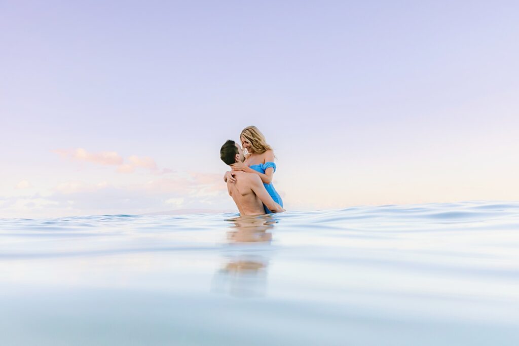 woman jumps into the arms of her husband while on their maui honeymoon in wailea