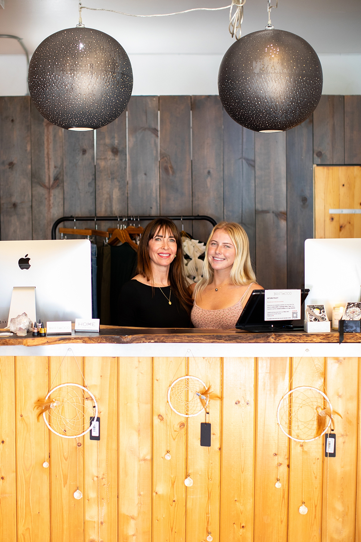 carrie gibb and shop employee smiling for camera behind a counter at their maui location