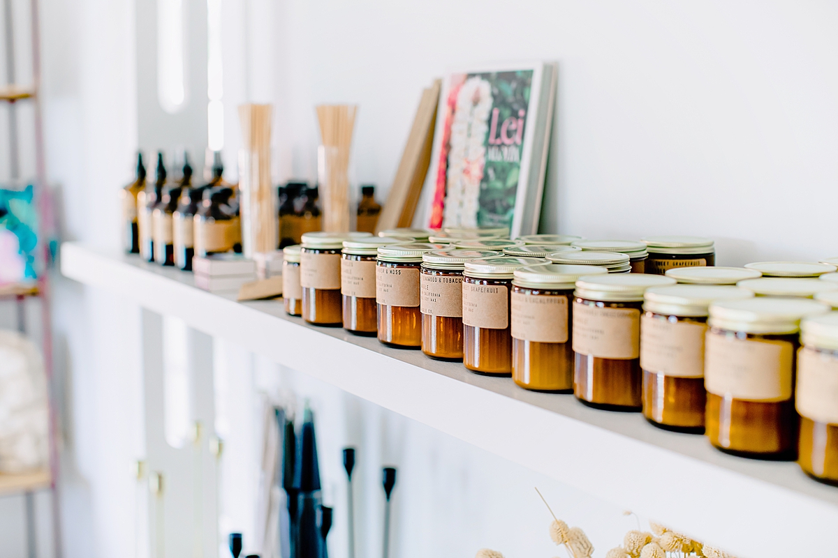 country chic candles line a shelf with bright white lighting inside a welcoming shop in upcountry maui