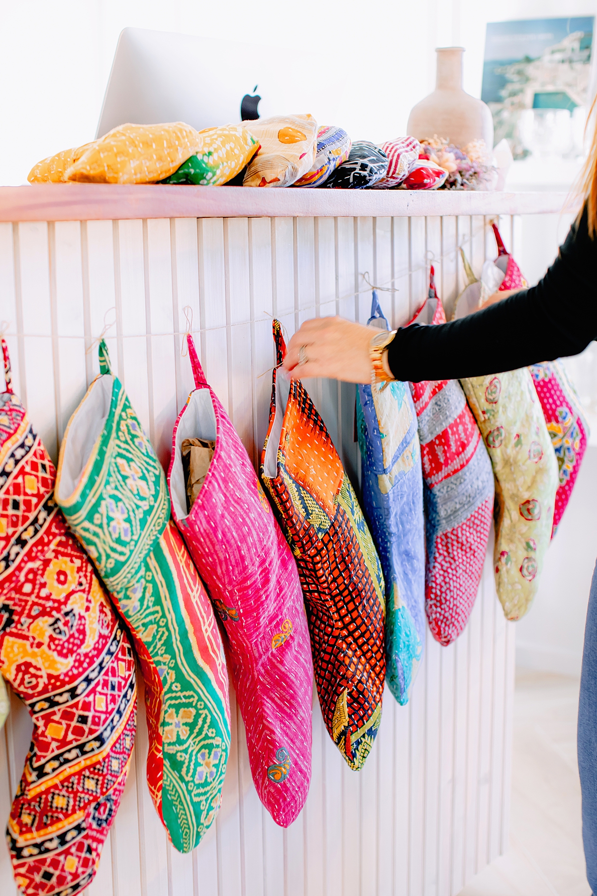 unique patchwork stockings hang from a counter display photographed as part of a small business feature on Maui by love and water