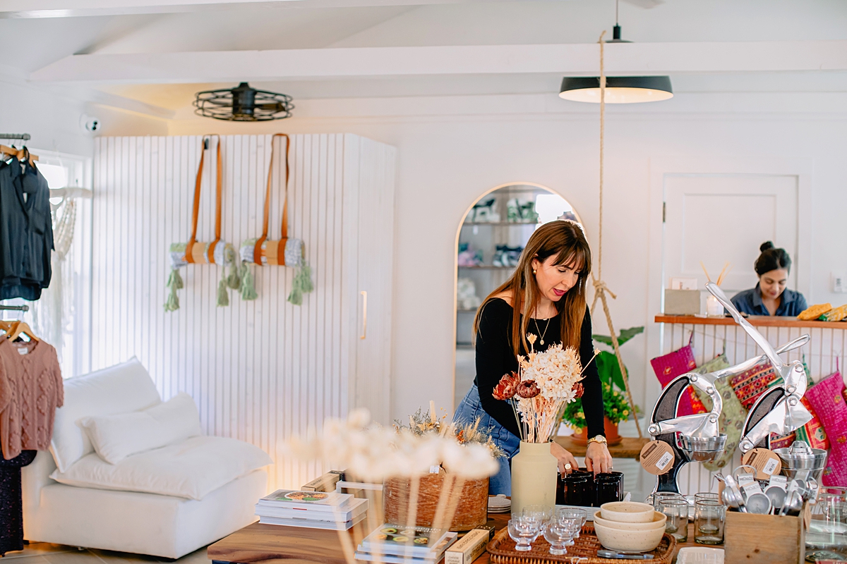 home by driftwood owner carrie gibb arranges homewares on a table inside her store on Makawao Avenue in maui