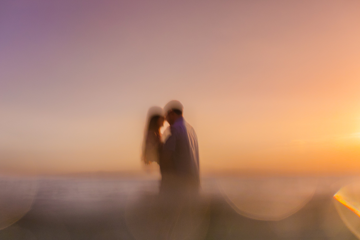 intentionally blurry image of a couple in the ocean kissing in wailea photographed by maui couples photographer love and water