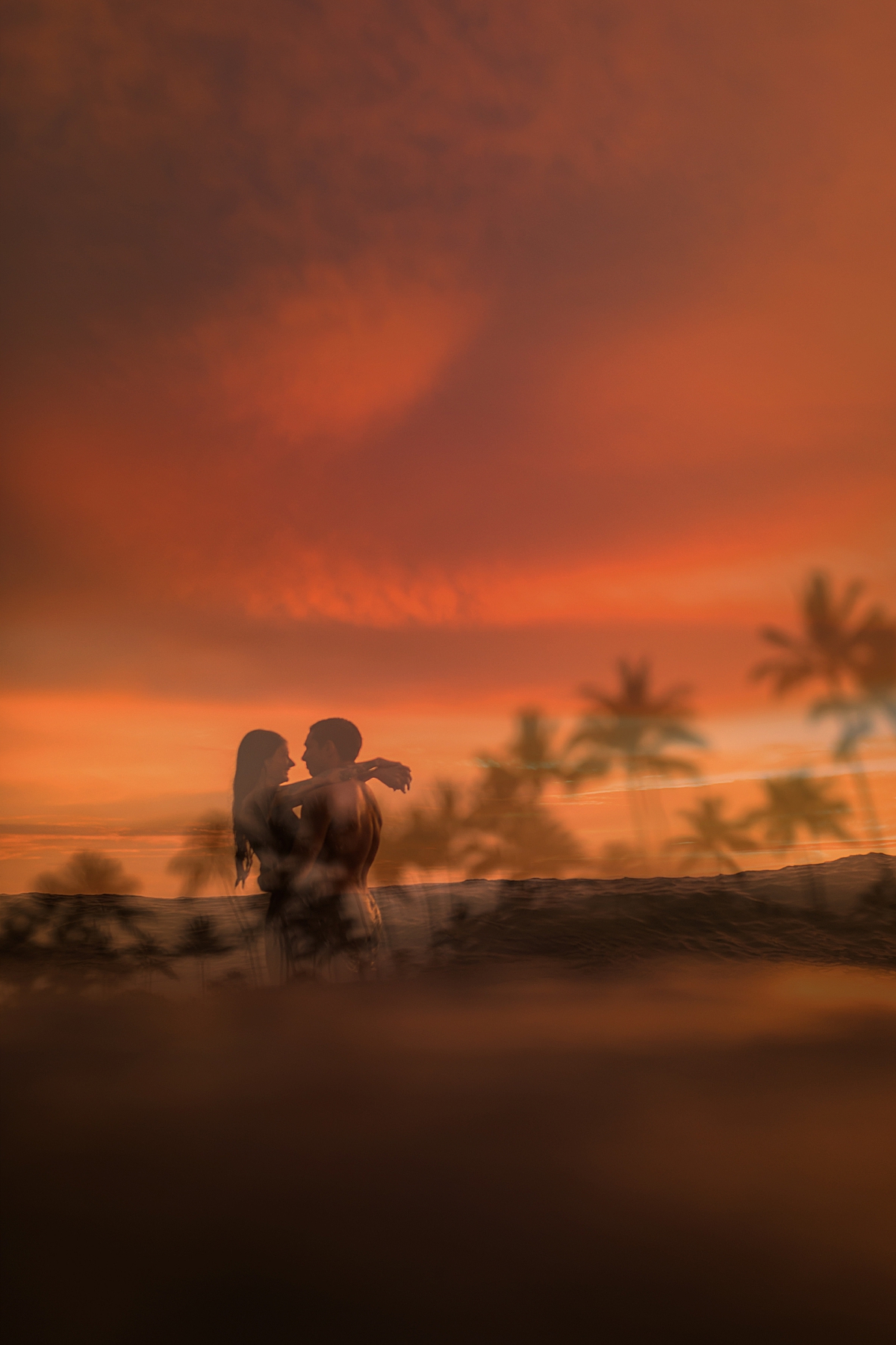 Love and Water Photography captures a rainy-day ocean kiss on Maui with a beautiful post-storm sunset in the background as a double exposure