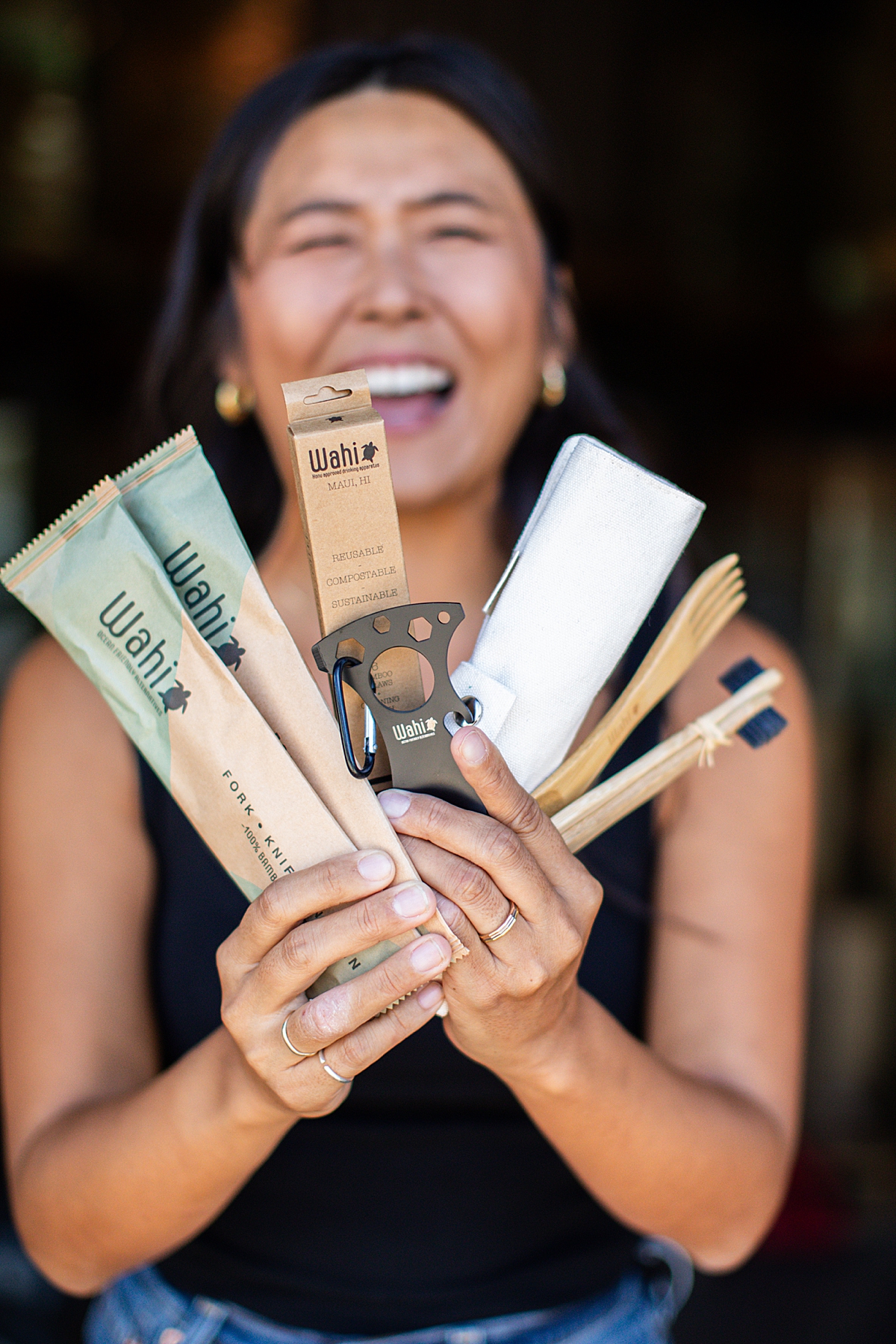 woman smiles and holds up reusable bamboo items