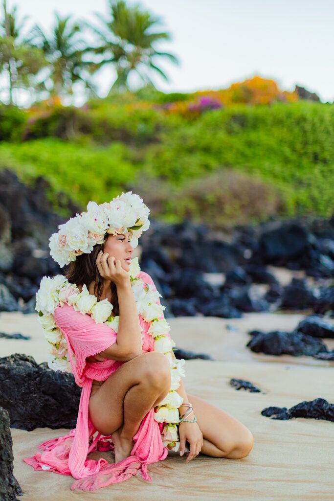 woman crouching on the sand during her sunrise portrait session I Wailea shot by love and water photography