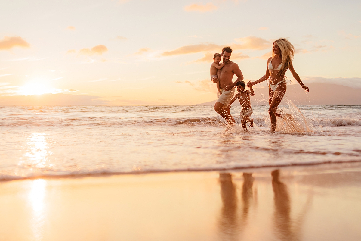 family running along the beach being photographed in wailea by love and water photography
