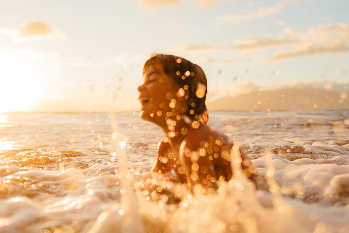 image of a child in the ocean during a what to pack for a morning at the beach session on Maui
