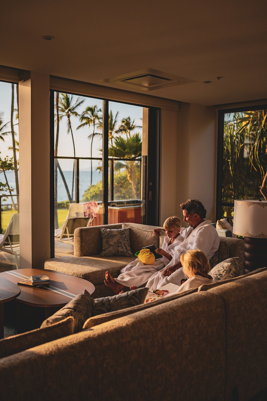 dad on the couch reads to son and daughter in the afternoon light at andaz resort