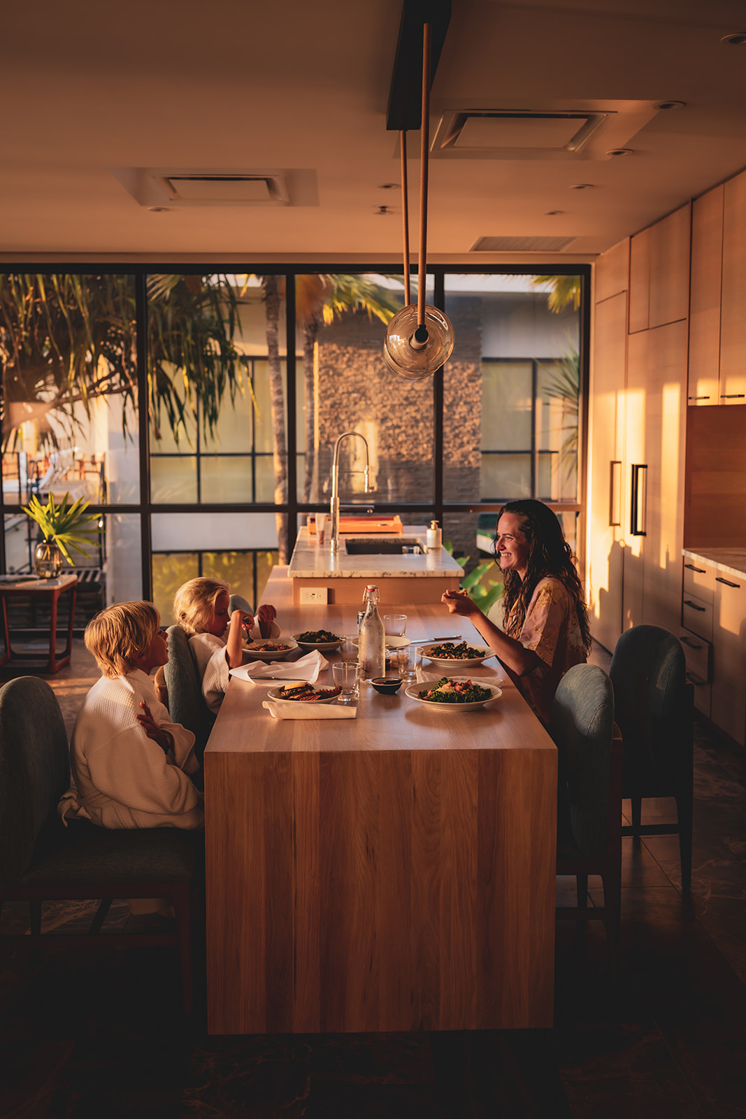 mom laughs with kids as they enjoy room service at makai ocean front villas in wailea